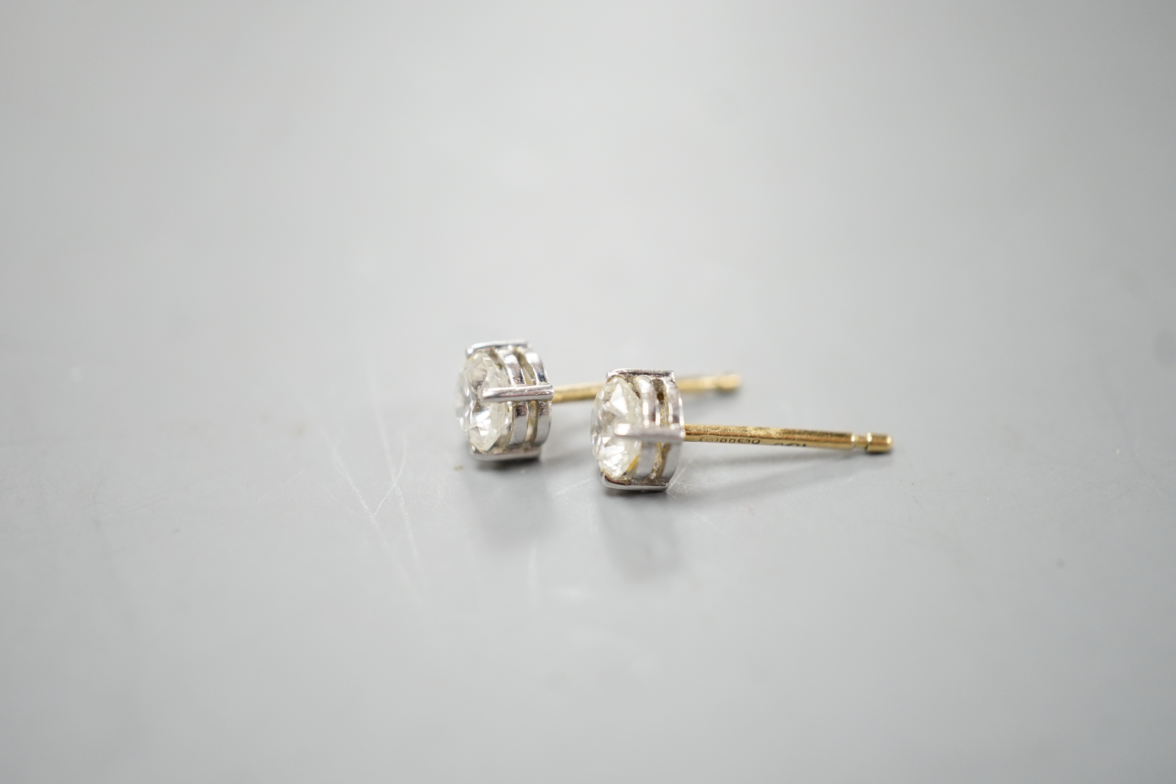 A pair of 18ct gold and solitaire diamond set ear studs, stone diameter approx. 4.8mm, gross weight 1.2 grams.